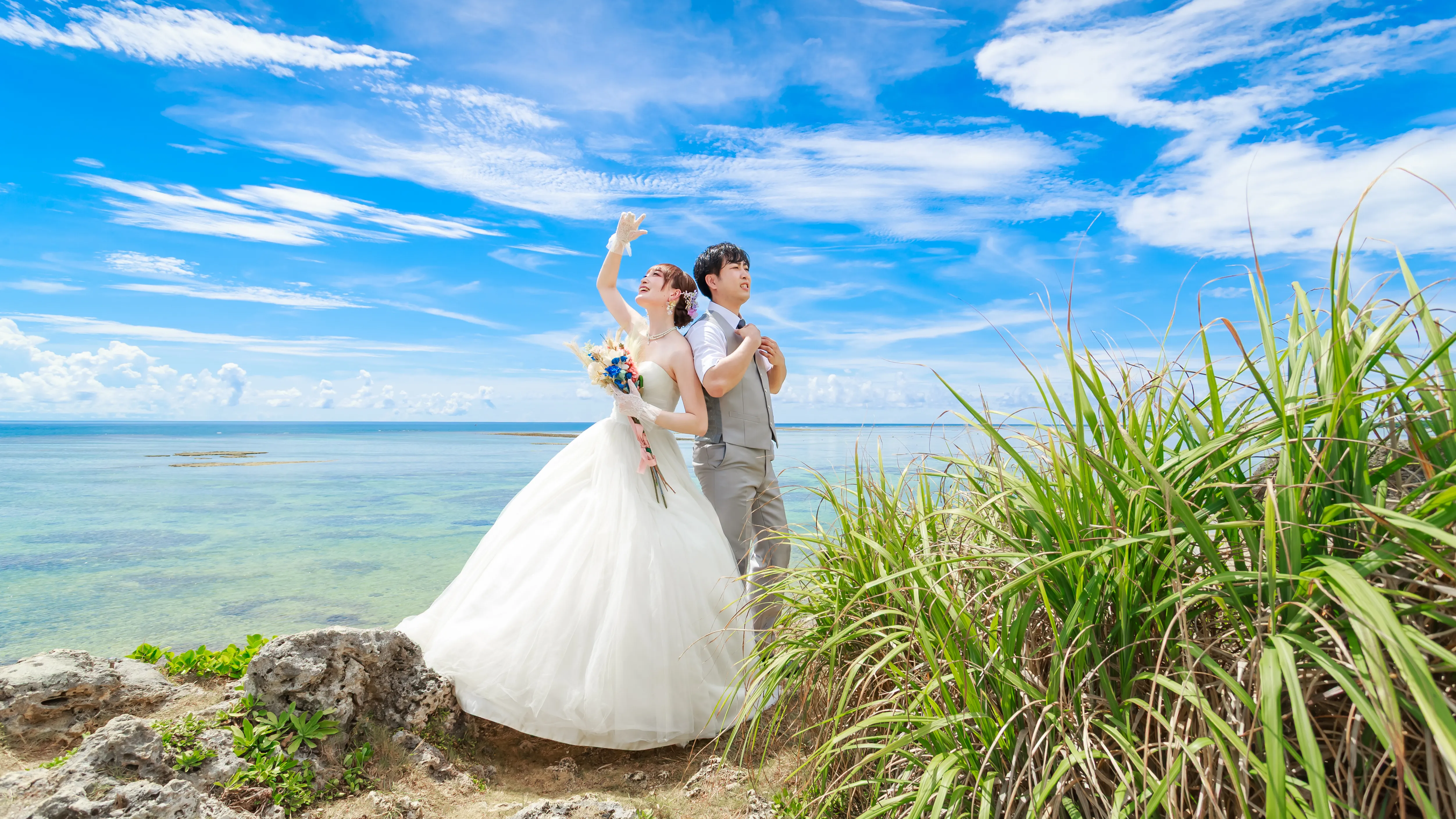 沖縄フォトウェディング カナイビーチで撮影した新郎新婦 青空と海を背景に