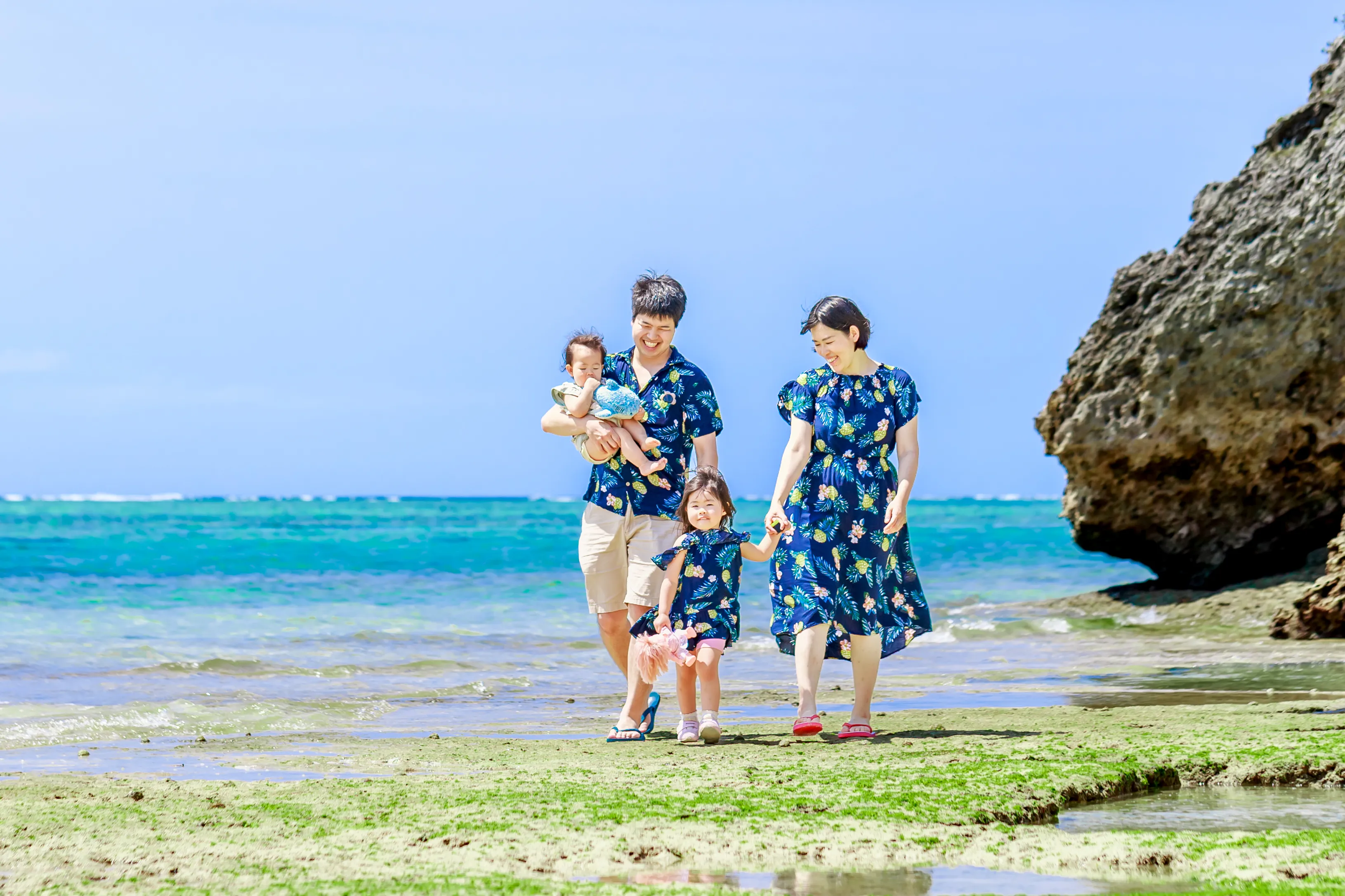 カナイビーチのさらさらな砂浜に座る家族